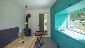 Uma cozinha moderna com painel de parede verde-água, uma mesa de jantar de madeira e uma janela com vista para o exterior.