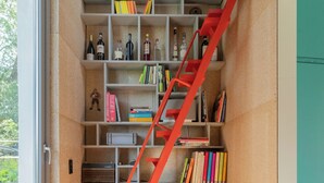 Quarto compacto e moderno com estante embutida e piso de madeira.