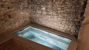 A stone-walled room with a rectangular stone bathtub. - House in the heart of the village (Cornillon)