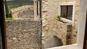 A stone building with a window and a stone wall. - House in the heart of the village (Cornillon)