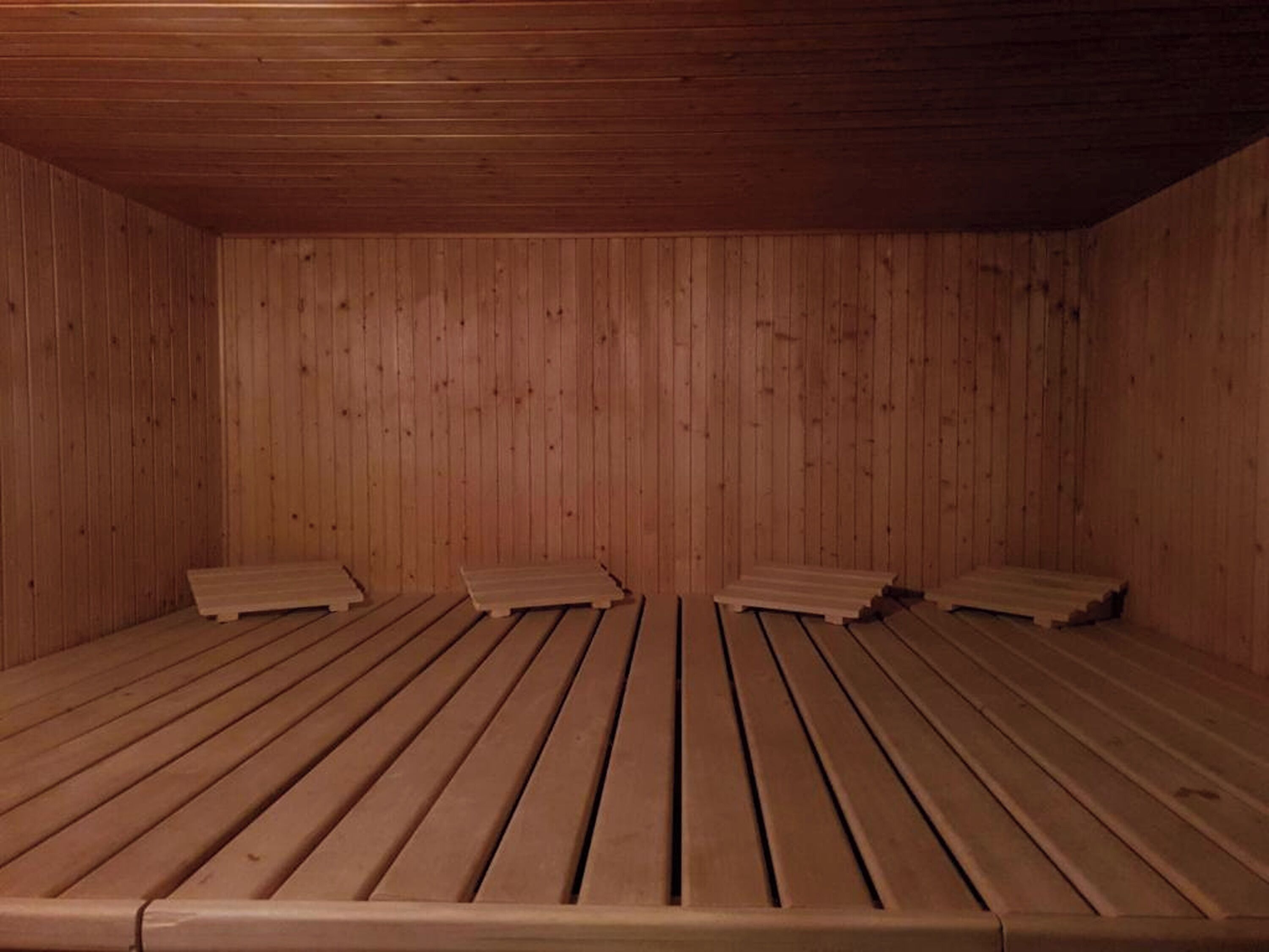 Un sauna con bancos y paredes de madera.