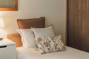 A bed with a wooden headboard, a bedside table with a lamp, and a wooden wardrobe. - JS xiaozhai・yuishima (Osaka)