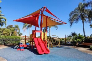 A playground with a slide and climbing structures. - Cozy, Perfect for Families, Hot Tub & Grill - 3013 (Kissimmee)