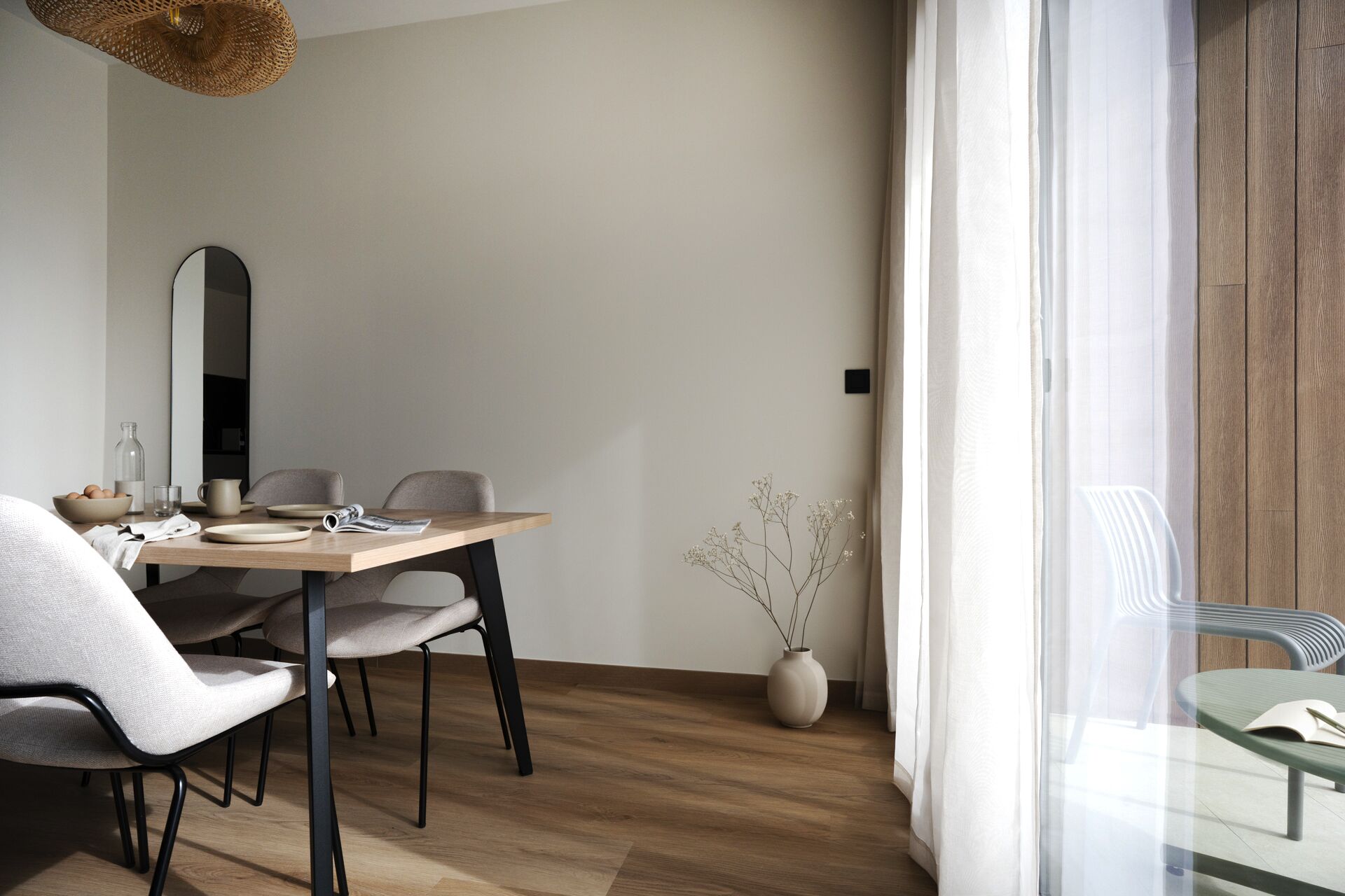 A modern dining area with a wooden table, chairs, and a vase of flowers.