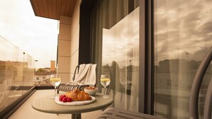 A balcony with a table set for breakfast, including croissants, raspberries, and glasses of wine. - Alora Apartamentos Mérida (Mérida)