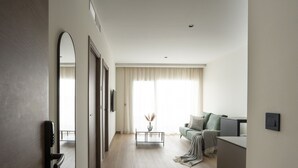 A modern living room with a sofa, a coffee table, and a TV. - Alora Apartamentos Mérida (Mérida)