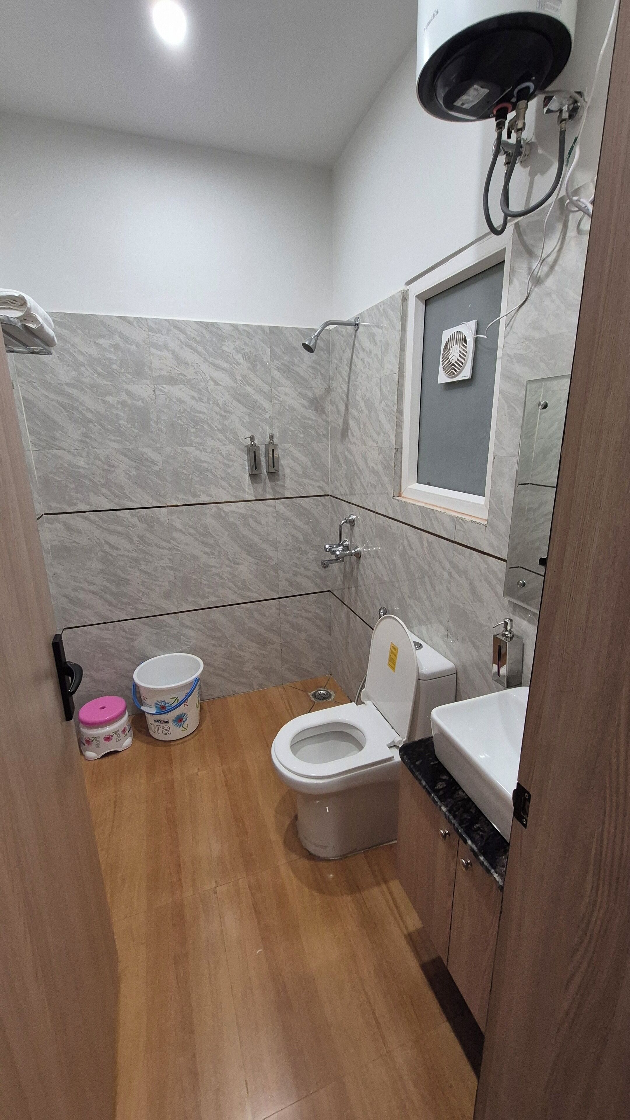 A bathroom with a toilet, sink, and shower.