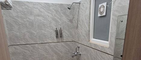 A bathroom with a toilet, sink, and shower.