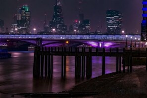 A nighttime cityscape with a bridge and illuminated buildings. - 7VH Virginia House, 31 Bloomsbury Way by City Living London (London)