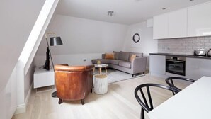 Una sala de estar moderna con un sofá, una mesa baja y una zona de comedor con sillas.