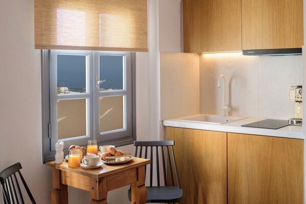 Una preparación para el desayuno con una mesa, sillas y vistas por una ventana.