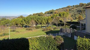 Ein Wohngebiet mit Blick auf eine hügelige Landschaft, einem Holzzaun und einem klaren Himmel.