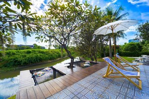 A wooden deck with a pool, lounge chairs, and an umbrella. - Fantastic 7 Bungalow Private Resort BR7 (Cha-am)