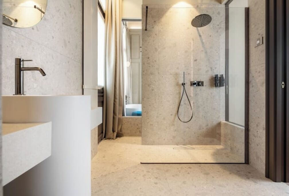 A modern bathroom with a freestanding bathtub, a shower, and a vanity with a mirror.