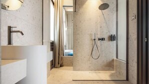 A modern bathroom with a freestanding bathtub, a shower, and a vanity with a mirror. - Suite..... (Iseo)