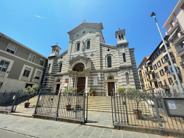 A historic church with a prominent bell tower and a large arched entrance. - Ostello San Giovanni Bosco (La Spezia)