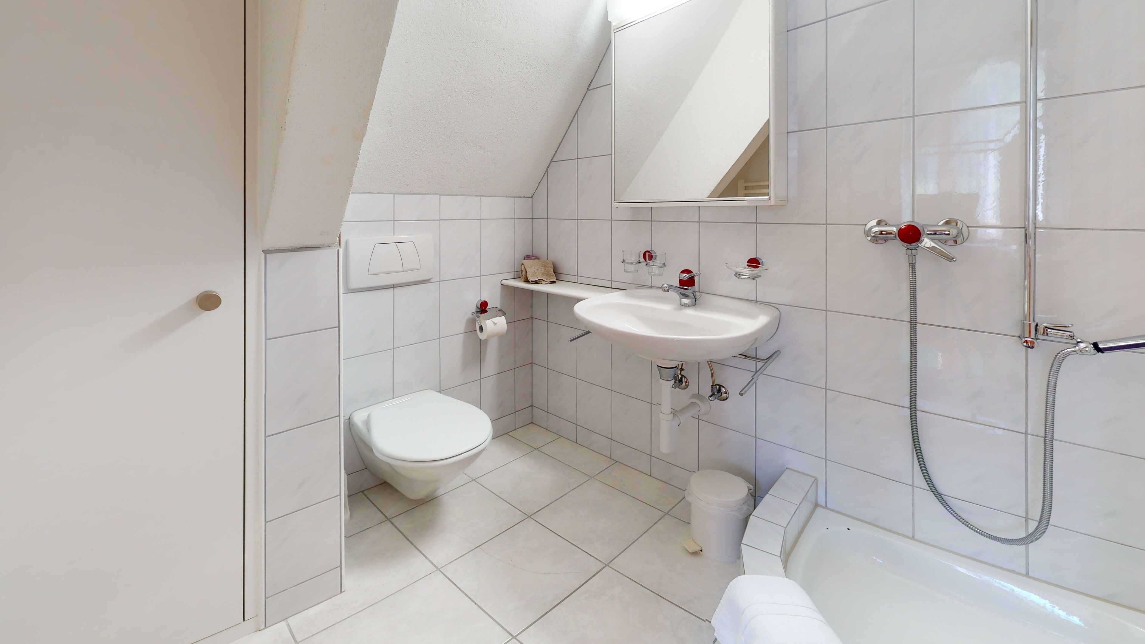 A modern bathroom with a toilet, sink, and shower.