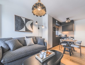 Una sala de estar moderna con un sofá, una mesa de centro y un comedor con sillas y una mesa.