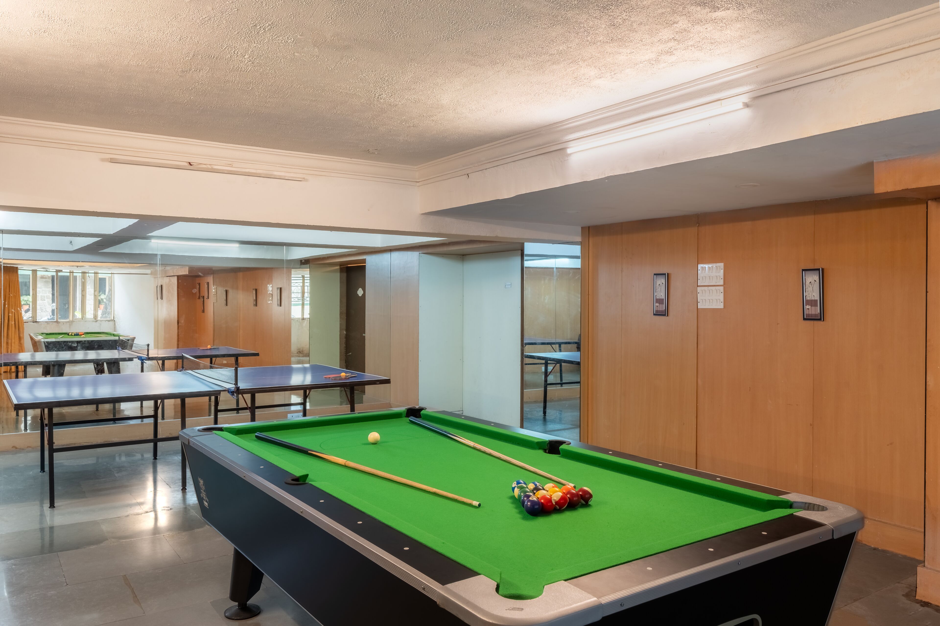 A pool table with balls, a billiards cue, and a green felt surface.