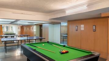 A pool table with balls, a billiards cue, and a green felt surface.