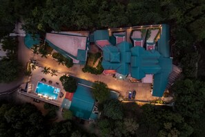 An aerial view of a resort with a swimming pool, multiple buildings, and surrounding greenery. - Velvet County Resort (Lonavala)