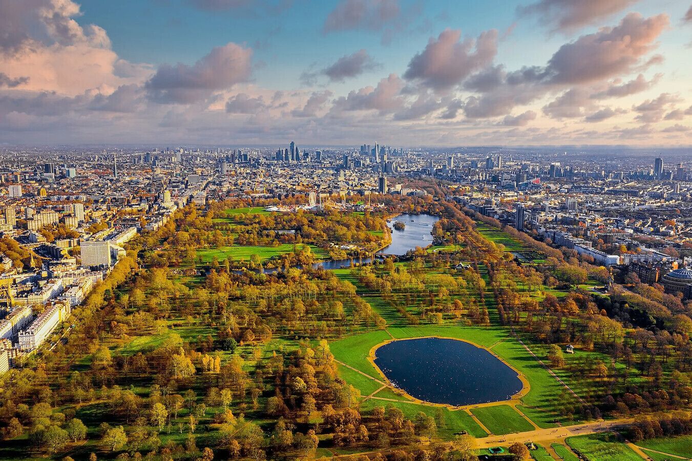 Vue aérienne d’une ville avec un grand parc comprenant un lac et une végétation luxuriante.