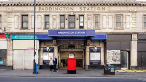Paddington Station met een bord van de Metropolitan Railway, een Eurochange wisselkantoor en een rode brievenbus.