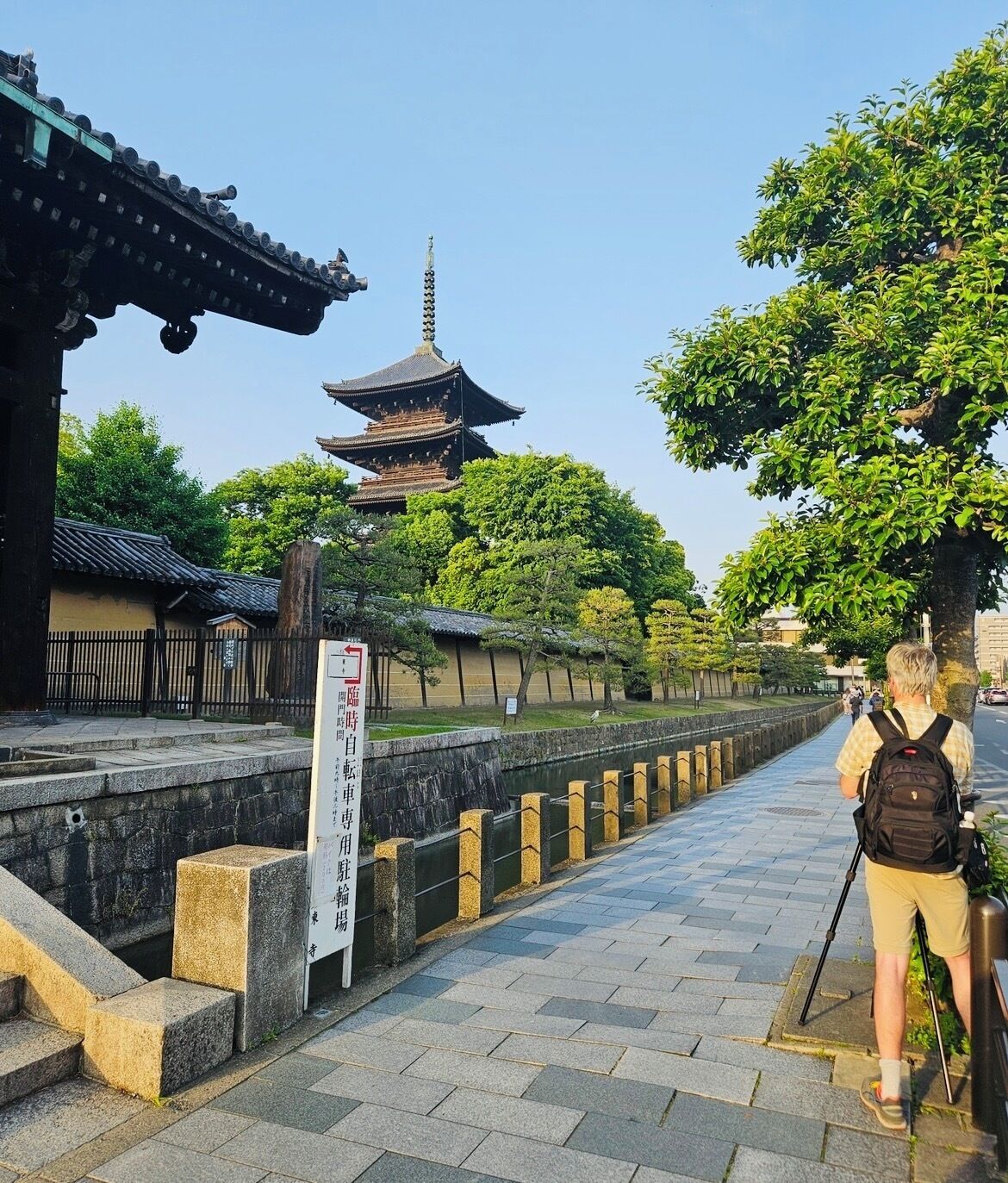 A traditional Japanese temple with a pagoda, stone pathway, and a signboard.
