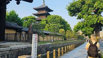 A traditional Japanese temple with a pagoda, stone pathway, and a signboard.