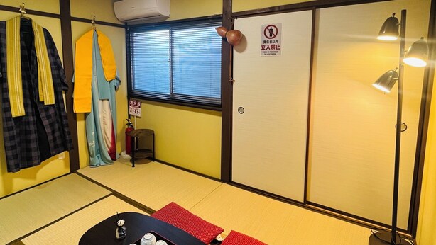 A tatami mat room with a table set for tea, a heater, and a window with blinds. - THE KAGAYA KYOTO hachijokuchi (Kyoto)