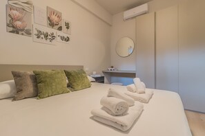A neatly made bed with rolled towels, a mirror, and artwork on the wall. - The Paraguays by Varenna Holidays (Bellano)