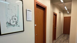 Ein Flur mit Holztüren, einer gerahmten Architekturzeichnung und einem Schild an der Wand.