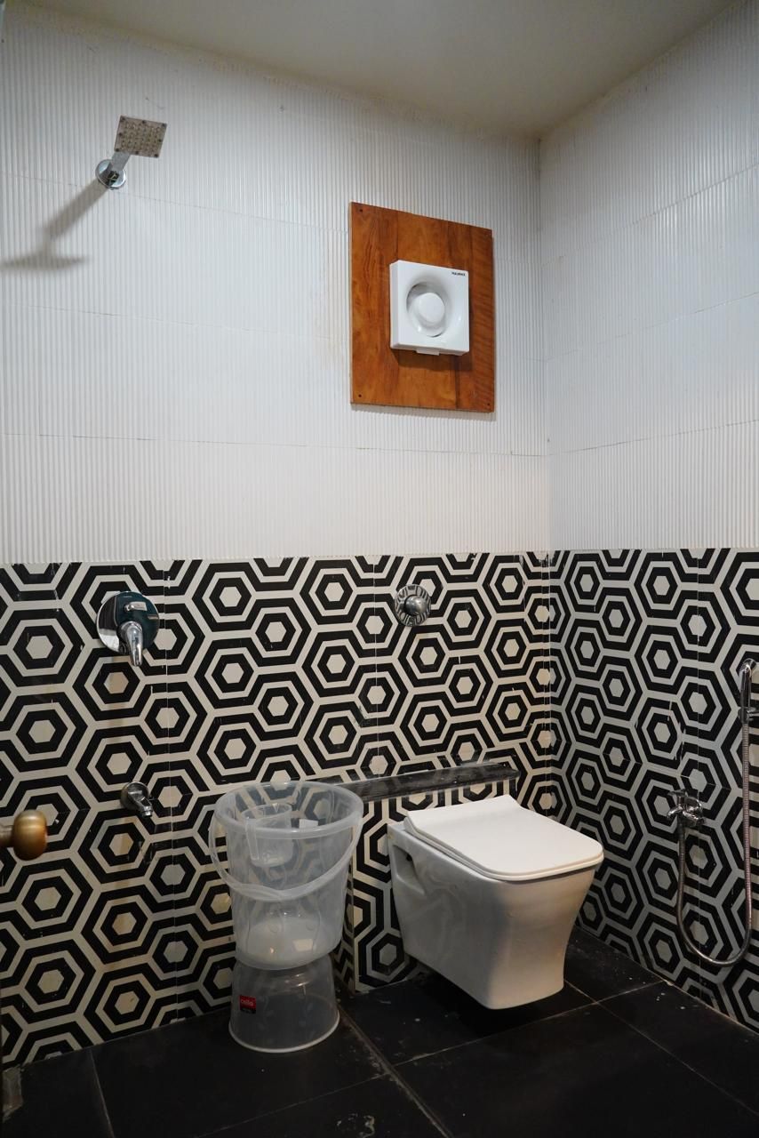 A bathroom with a toilet, a shower, and a hand dryer.