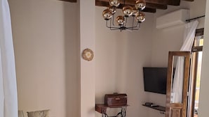 Ein Wohnzimmer mit einer Couch, einem Couchtisch mit Dekoration, einer Nähmaschine und einem Fernseher.