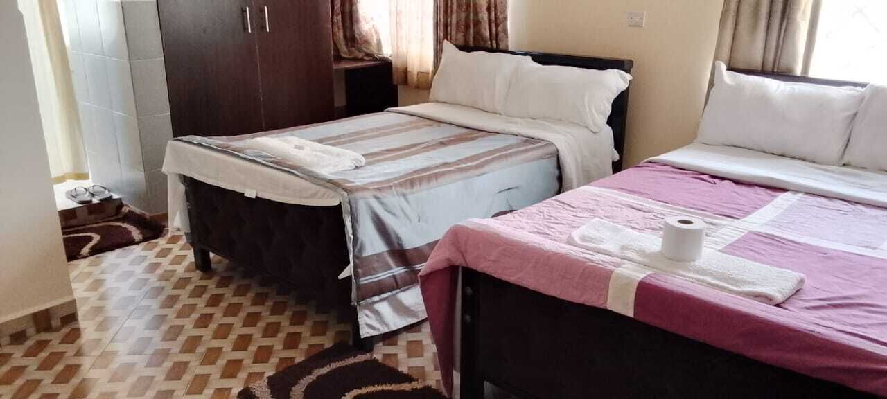 Un dormitorio con dos camas, un armario y un suelo estampado.