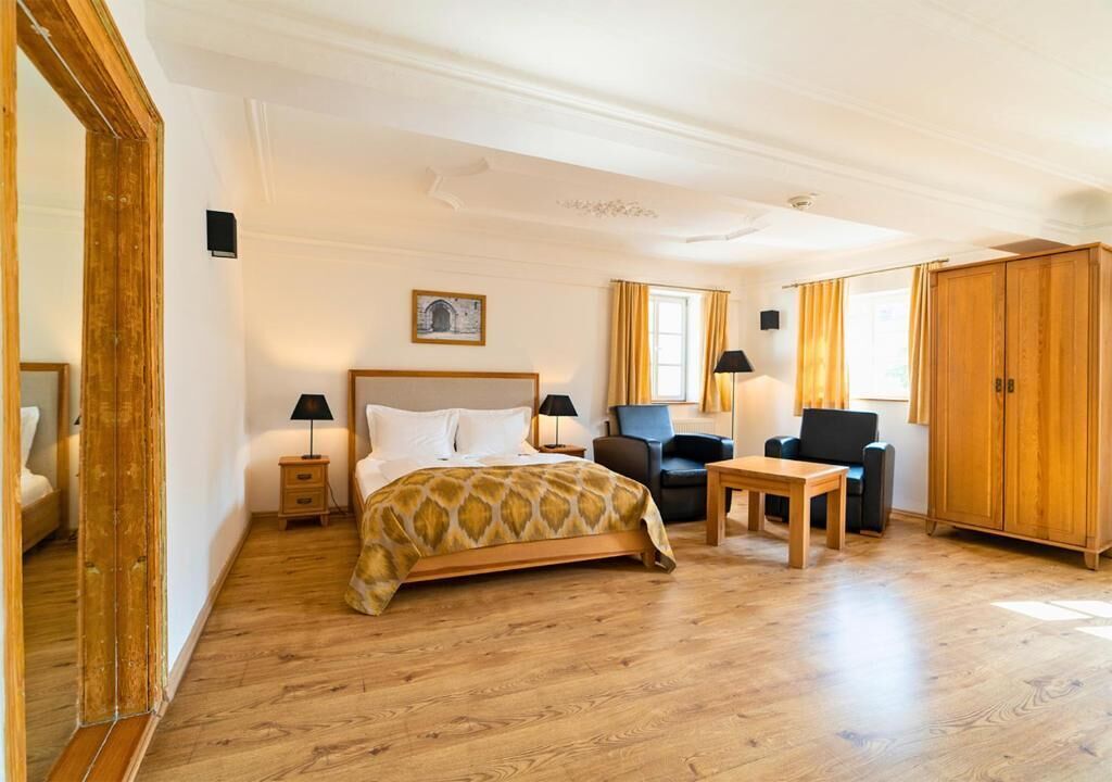 Ett hotellrum med en säng, ett skrivbord, en stol, en garderob och ett nattduksbord.