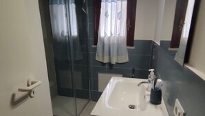 A bathroom with a glass shower enclosure, a sink with a mirror, and a towel rack. - Casa Sole di Sicilia: Sea View, Wi-Fi & Air Conditioning in San Vito Lo Capo (San Vito Lo Capo)