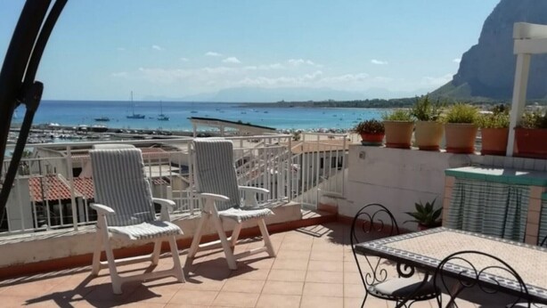 A terrace with white chairs, a table, and potted plants. - Casa Sole di Sicilia: Sea View, Wi-Fi & Air Conditioning in San Vito Lo Capo (San Vito Lo Capo)
