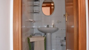 A bathroom with a large sink, a mirror, and a towel rack.