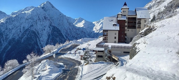 A snow-covered mountain resort with a multi-story building featuring balconies and a ski lift. - LES 2 ALPES, comfortable one-bedroom apartment with a private covered parking space at the foot of the slopes (Les Deux Alpes)