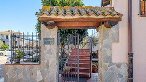 A stone entrance with a metal gate, a staircase, and a sign that reads 'LA ROCA.' - Triple Room with Mountain View, Shared Terrace and Wi-Fi (Telti)