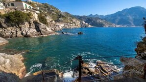 Un paysage côtier avec un terrain rocheux et une mer bleue et limpide.