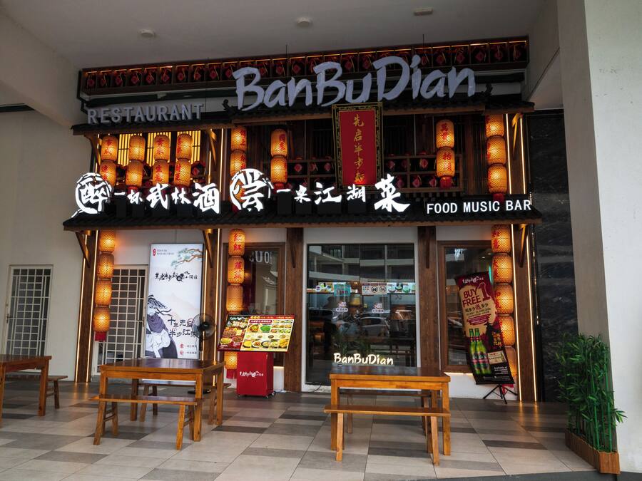 A restaurant with a traditional Chinese sign, a food music bar, and a menu display outside.