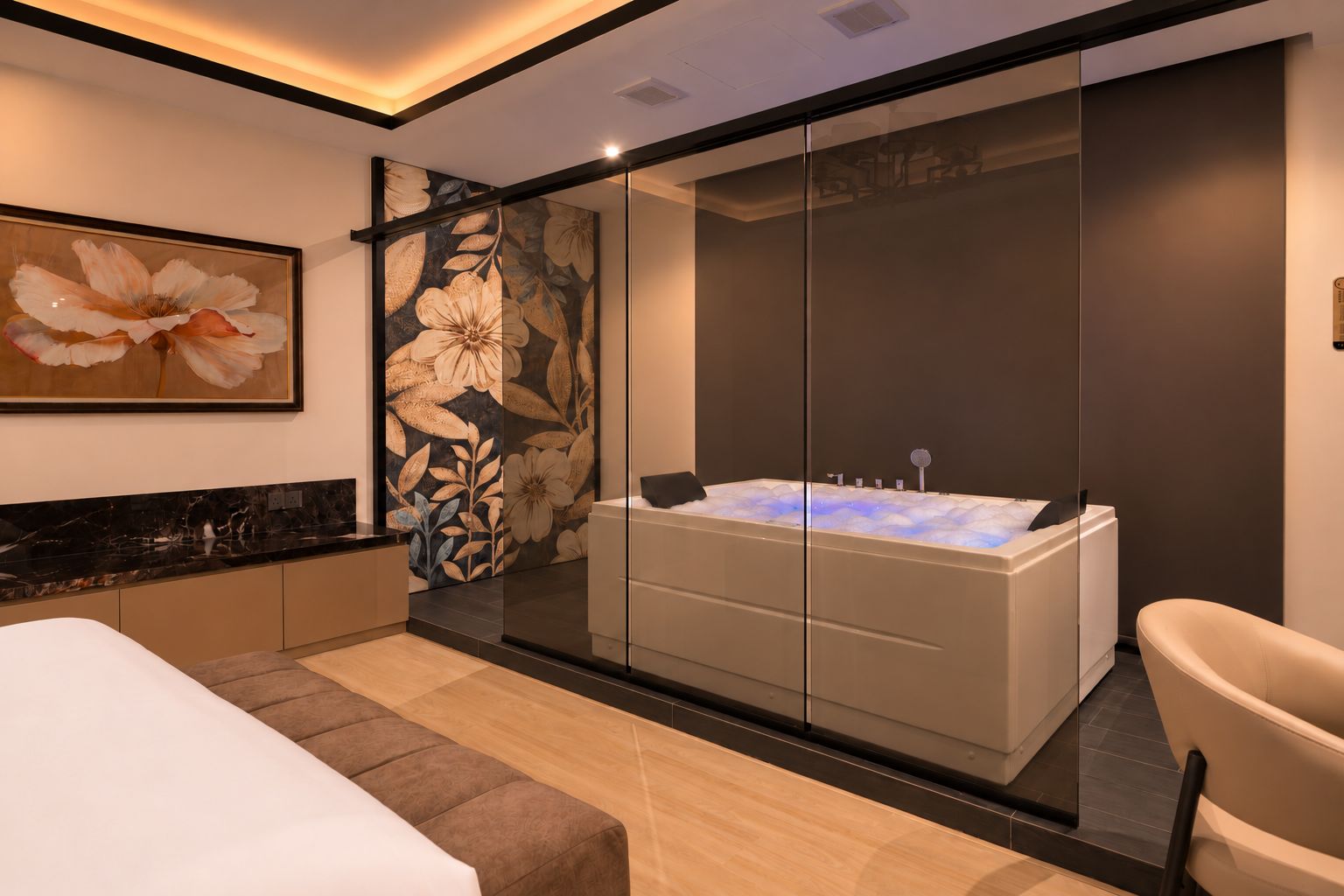 A modern bathroom with a glass-enclosed jacuzzi, a large mirror, and a floral artwork on the wall.