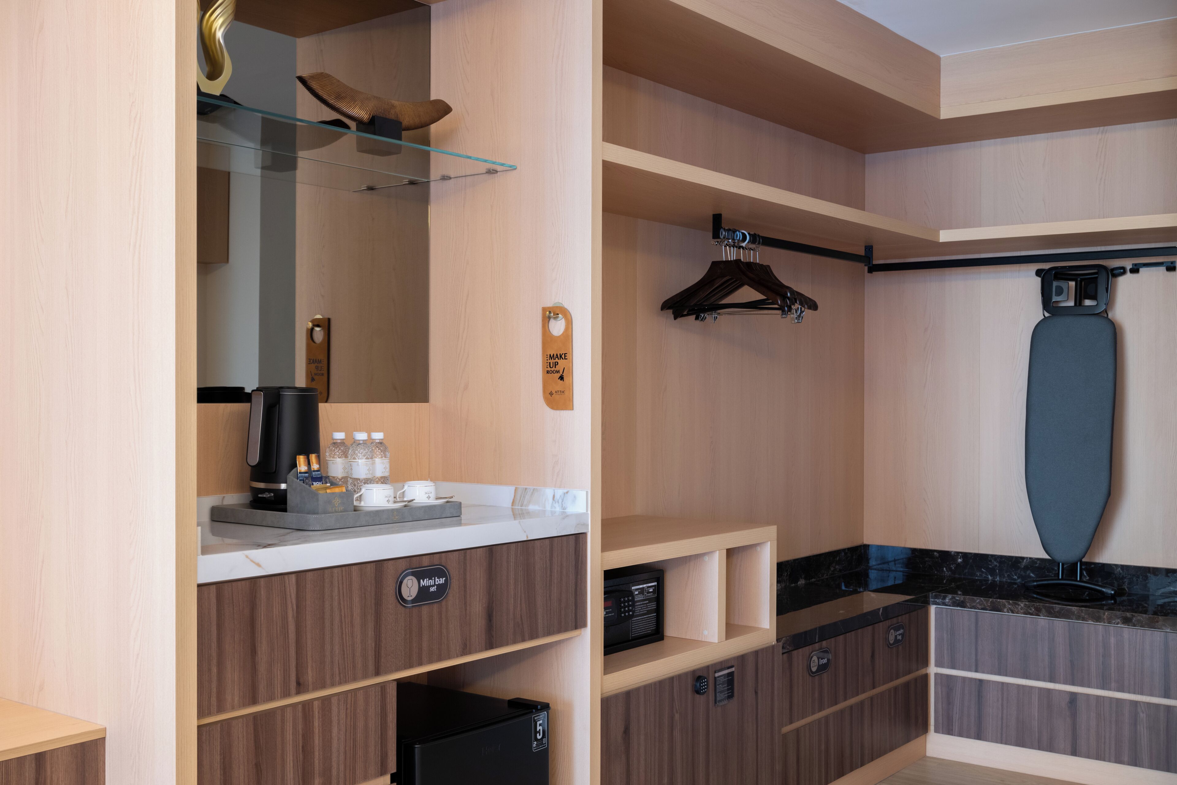 A modern bathroom with a coffee machine, mini bar, and a large mirror.