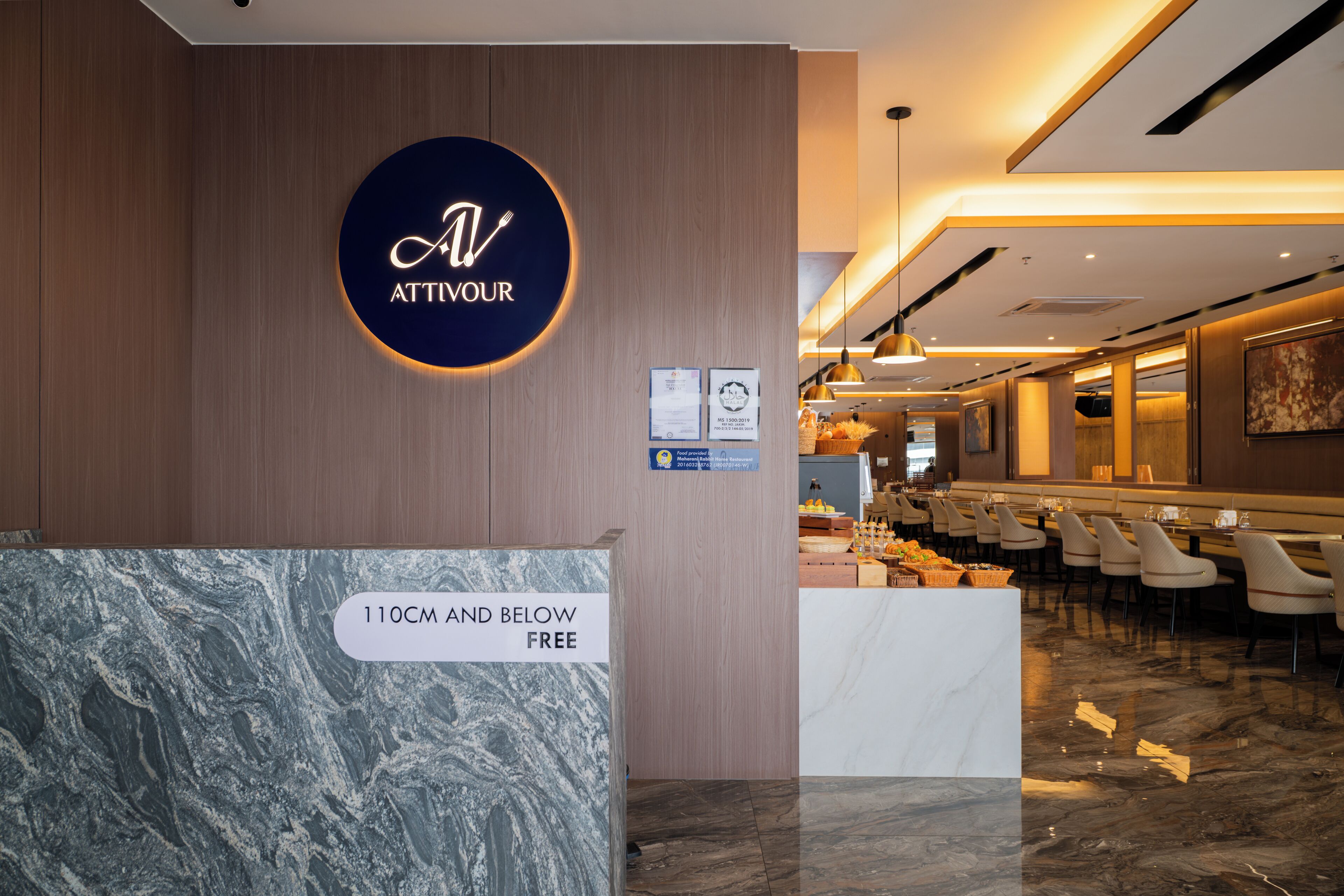 A reception area with a marble counter, a sign reading 'ATTIVOUR,' and a seating area with tables and chairs.
