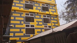 En byggnad med flera våningar och en iögonfallande fasad med geometriska mönster i gult och grått.