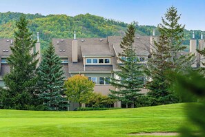 A residential building with multiple chimneys, surrounded by well-maintained lawns and trees. - The Mountain House - Walk to the Village! (The Blue Mountains)