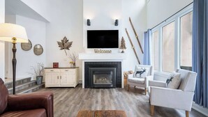 A living room with a fireplace, a television, and a sofa. - The Mountain House - Walk to the Village! (The Blue Mountains)