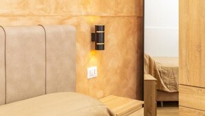 Una camera da letto con una testiera in legno, un comodino e una lampada a parete.